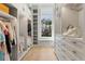 Bright walk-in closet featuring custom shelving, storage drawers, natural light, and hardwood floors at 8501 Midnight Pass Rd, Sarasota, FL 34242