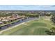 Picturesque aerial view of a residential area featuring houses, a tranquil lake, and a lush green golf course at 15608 Leven Links Pl, Lakewood Ranch, FL 34202