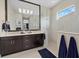 Bathroom featuring double vanity, large mirror, walk-in shower and modern finishes at 15608 Leven Links Pl, Lakewood Ranch, FL 34202