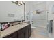 Modern bathroom featuring a dark wood vanity, a large mirror, and a shower/tub combo with glass doors at 15608 Leven Links Pl, Lakewood Ranch, FL 34202