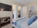 Bedroom featuring a mounted TV, desk and access to bathroom and walk-in closet at 15608 Leven Links Pl, Lakewood Ranch, FL 34202