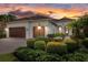 Home with lush landscaping, brick paver driveway, two-car garage, and inviting entryway at 15608 Leven Links Pl, Lakewood Ranch, FL 34202