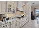 White kitchen with granite countertops, decorative tile backsplash, and stainless steel appliances at 15608 Leven Links Pl, Lakewood Ranch, FL 34202