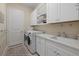 Bright laundry room features modern appliances, white cabinets, and a convenient sink at 15608 Leven Links Pl, Lakewood Ranch, FL 34202