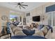 Bright living room with a large sectional, TV, and access to the outdoor screened-in lanai at 15608 Leven Links Pl, Lakewood Ranch, FL 34202