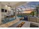 The outdoor kitchen and dining area offers stunning views of the pool, lake and a cozy fire pit lounge at 15608 Leven Links Pl, Lakewood Ranch, FL 34202