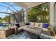 Inviting screened patio boasts a cozy seating area with fire pit and scenic views of the pool and tropical landscaping at 15608 Leven Links Pl, Lakewood Ranch, FL 34202
