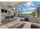 Covered patio view of beautiful pool and lake with outdoor kitchen and seating at 15608 Leven Links Pl, Lakewood Ranch, FL 34202