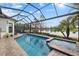 Stunning pool and spa area overlooking a serene lake, framed by a screened enclosure and lush landscaping at 15608 Leven Links Pl, Lakewood Ranch, FL 34202