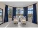 Bright sitting room with comfortable chairs, dark blue curtains, and a large window overlooking the water at 15608 Leven Links Pl, Lakewood Ranch, FL 34202