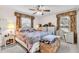 Cozy bedroom featuring a ceiling fan, two windows, and wicker furniture at 1817 Curry Ave # 57, Nokomis, FL 34275