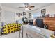 Bright bedroom featuring a ceiling fan, a bed with yellow quilt, and a large desk area at 1817 Curry Ave # 57, Nokomis, FL 34275