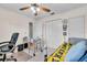 Bedroom featuring a ceiling fan, closet, bed with yellow quilt, and a white wheeled desk at 1817 Curry Ave # 57, Nokomis, FL 34275