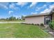 View of the side of the single-story home surrounded by green lawn and small green bushes at 1817 Curry Ave # 57, Nokomis, FL 34275