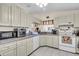 A well-lit kitchen featuring white cabinets, appliances, and tile flooring at 1817 Curry Ave # 57, Nokomis, FL 34275