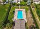 Aerial view of a fenced pool area featuring a rectangular pool, lounge chairs, and a covered cabana at 1817 Curry Ave # 57, Nokomis, FL 34275