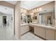 Bright bathroom with dual sinks, vanity area, and well lit mirror; view into hallway at 1922 Harbourside Dr # 1102, Longboat Key, FL 34228