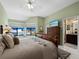 Bright bedroom with an ensuite bathroom, tropical ceiling fan, and lush tropical outdoor view at 1922 Harbourside Dr # 1102, Longboat Key, FL 34228