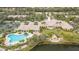 Aerial view of community clubhouse featuring a large pool, palm trees, and lakeside gazebo at 5521 Bilbao Pl, Sarasota, FL 34238