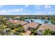Aerial view of a residential neighborhood with lush landscaping and a central lake at 5521 Bilbao Pl, Sarasota, FL 34238
