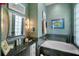 Bathroom with tile accents around the tub and sink areas, highlighted by decorative mirrors and lighting fixtures at 5521 Bilbao Pl, Sarasota, FL 34238