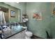 Bathroom featuring a glass vessel sink, unique wall art, and neutral tiling, offering a modern aesthetic at 5521 Bilbao Pl, Sarasota, FL 34238