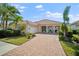 Charming single-story home with a brick driveway, lush landscaping, and a welcoming front porch at 5521 Bilbao Pl, Sarasota, FL 34238