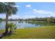 Scenic lake view with a palm tree in the foreground and waterfront homes in the distance at 5521 Bilbao Pl, Sarasota, FL 34238