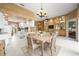 Open-concept living room featuring a modern chandelier, dining area, white kitchen, and built-in shelving with mirrored backs at 5521 Bilbao Pl, Sarasota, FL 34238