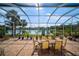 Outdoor patio with a dining table and seating overlooking a serene lake view at 5521 Bilbao Pl, Sarasota, FL 34238