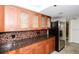Updated kitchen with stainless steel refrigerator, granite countertops, and wooden cabinets at 11 Sunset Dr # 406, Sarasota, FL 34236