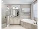Bright bathroom showcasing a bathtub with tile surround, a glass shower, and a vanity with granite countertops at 17459 Hickok Belt Loop, Bradenton, FL 34211