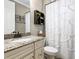 A charming full bathroom features a granite vanity, framed mirror, and a tub-shower combo with curtain at 17459 Hickok Belt Loop, Bradenton, FL 34211