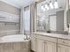 This main bathroom features a soaking tub, granite vanity, and tile surround at 17459 Hickok Belt Loop, Bradenton, FL 34211