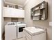 Well-organized laundry room features modern appliances, upper cabinets, and granite countertop sink at 17459 Hickok Belt Loop, Bradenton, FL 34211