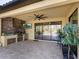 Outdoor kitchen featuring a brick backsplash, stainless steel grill, a ceiling fan, and a TV at 17459 Hickok Belt Loop, Bradenton, FL 34211