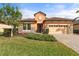Charming single-Gathering home with a well-manicured front yard, stone accents, and a paved driveway at 26720 Weiskopf Dr, Englewood, FL 34223