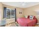 Cozy bedroom featuring a window view, a plush bed with unique pillows and colorful patterned carpet at 3443 Tallywood Cir # 7061, Sarasota, FL 34237