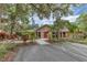 Inviting community clubhouse with a red door and surrounding mature landscaping for a peaceful setting at 3443 Tallywood Cir # 7061, Sarasota, FL 34237