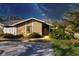 Charming single-story home with a well-manicured lawn and mature trees under a starlit sky at 3443 Tallywood Cir # 7061, Sarasota, FL 34237