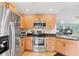Well-equipped kitchen boasts stainless steel appliances, a tiled backsplash, and ample wooden cabinetry at 3443 Tallywood Cir # 7061, Sarasota, FL 34237
