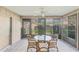Bright sunroom with tile floors, a glass-topped table, comfortable seating, and views of the outdoor landscape at 3443 Tallywood Cir # 7061, Sarasota, FL 34237