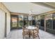 Inviting sunroom with tiled flooring, a glass table, four chairs, and large windows offering backyard views at 3443 Tallywood Cir # 7061, Sarasota, FL 34237
