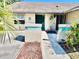 Inviting home entrance featuring a teal door, landscaped walkway, and colorful flowers at 4127 3Rd Ave W, Palmetto, FL 34221