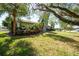 Landscaped front yard featuring mature trees, lush green grass, and colorful plants adding curb appeal to the home at 4419 Mangrove Point Rd, Bradenton, FL 34210