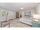 Relaxing bedroom featuring light wood floors, soft colors, a large picture window and a peek into the Primary bathroom at 4510 Banan Pl, Sarasota, FL 34242