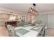 Elegant dining room with seating for ten, modern lighting fixture, and views to a bright, airy kitchen at 4510 Banan Pl, Sarasota, FL 34242