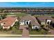 Aerial view of a luxurious home, with a well-manicured lawn, surrounded by lush greenery and water features at 4745 Benito Ct, Lakewood Ranch, FL 34211