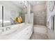Bright bathroom featuring a double sink vanity with marble countertops and a tub with tiled walls at 4745 Benito Ct, Lakewood Ranch, FL 34211