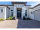 Stunning front entrance with double doors, manicured landscaping, and a brick paved drive at 4745 Benito Ct, Lakewood Ranch, FL 34211